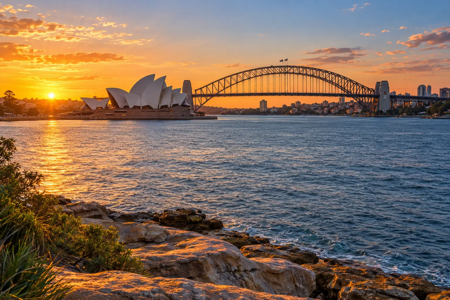Sydney Opera House and Harbour Bridge across the harbour at sunset